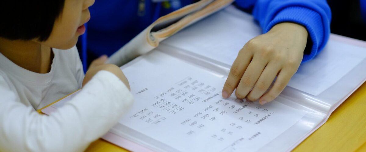 person teaching girl using book